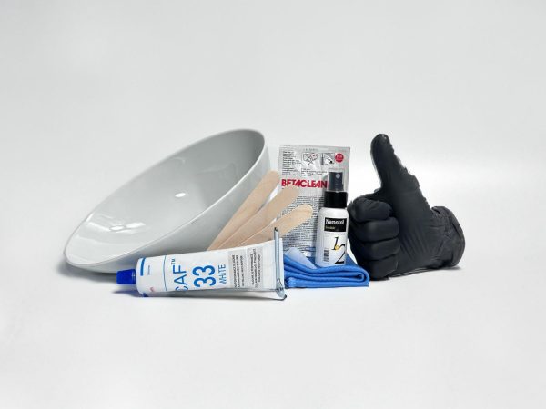 The Twusch installation kit laid out: porcelain insert, white silicone, three wooden spatulas, Nanotol refresher, cleaning pads, gloves and microfiber cloth.
